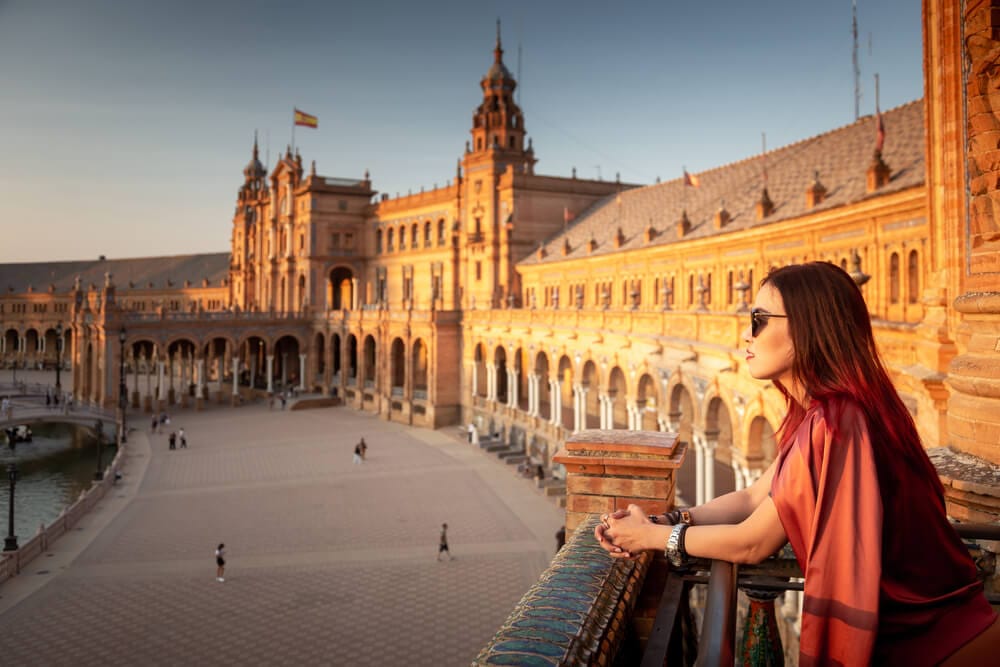 A woman stand in awe of Plaza de España in Seville while exploring Spain's glory on a private tour across Spain with her friends.